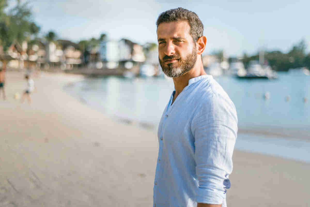Uomo con barba e camicia di lino in spiaggia