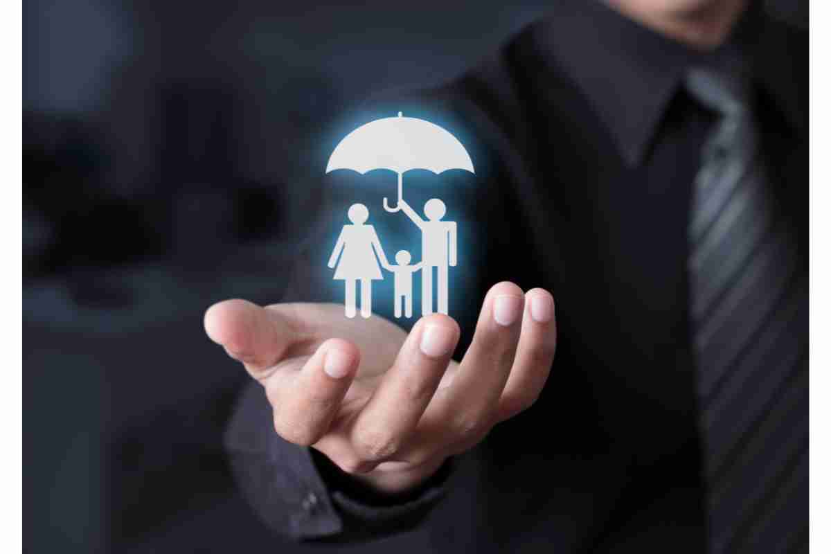 Assicuratore che ha fra le mani l'immagine di una famiglia sotto l'ombrello
